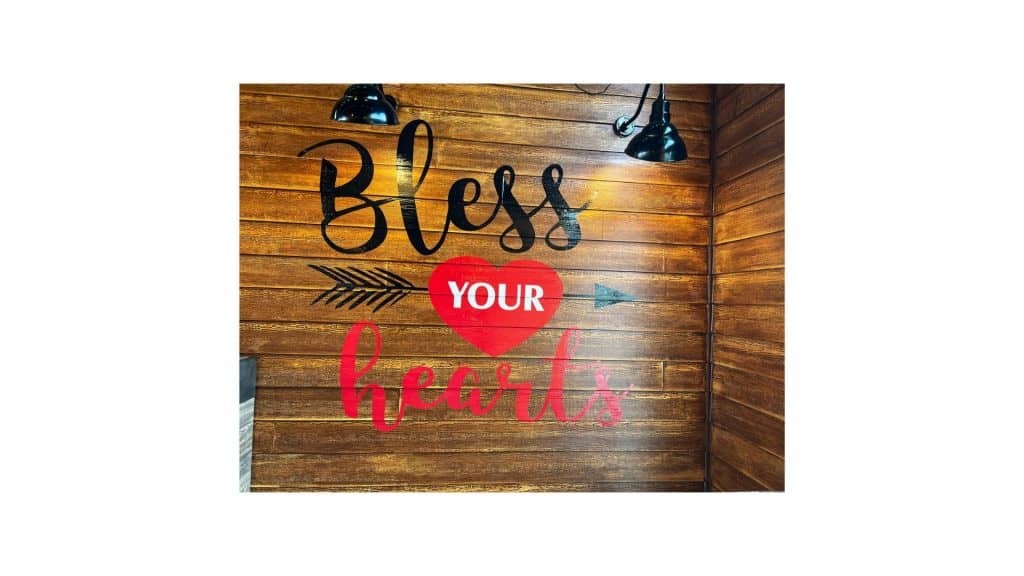 bless your hearts vinyl decal on wooden wall.