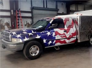 ford truck wrapped in American flag.